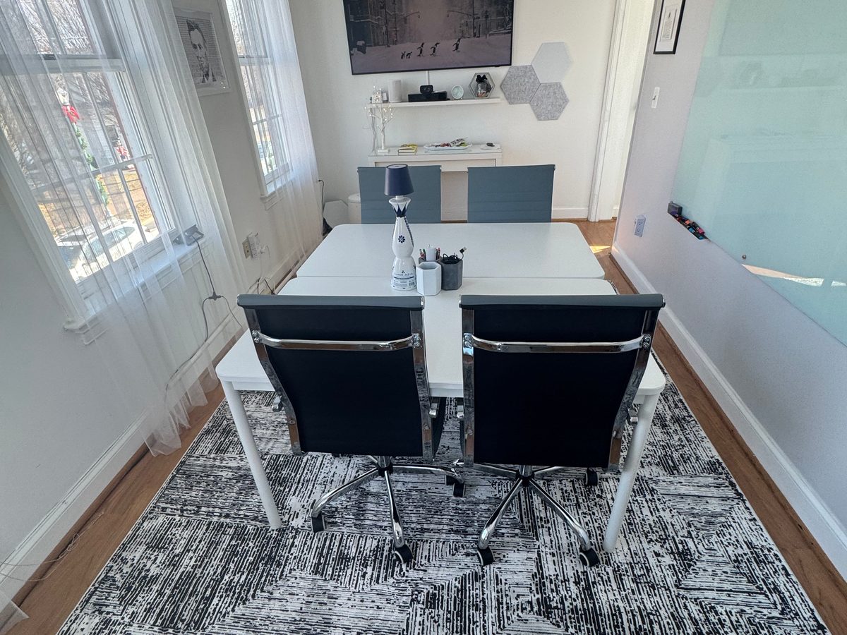 The Hive's conference room with a large table, display, and whiteboard walls
