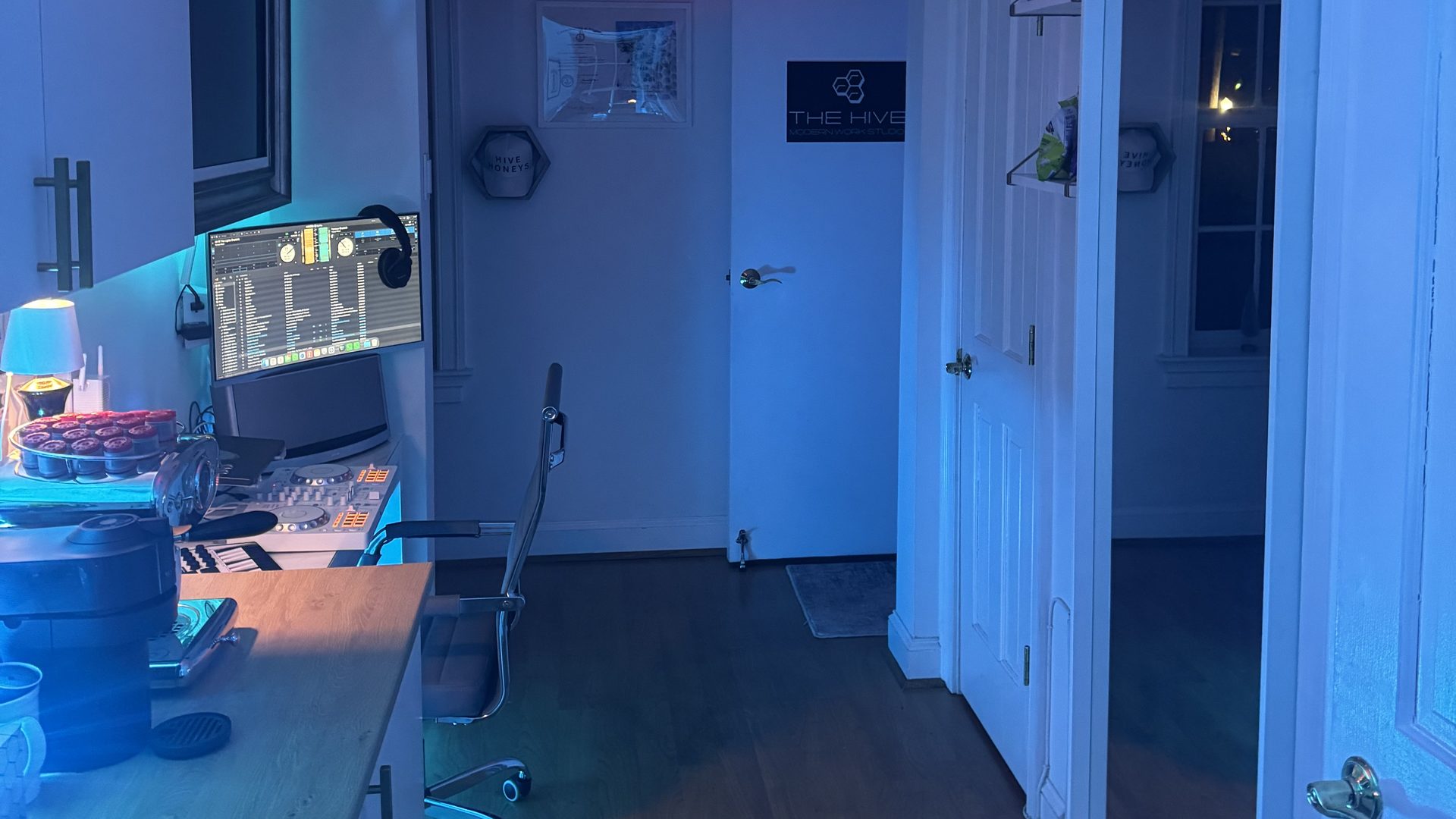 The Hive's LED-lit creative production studio with a recording desk and mixing console