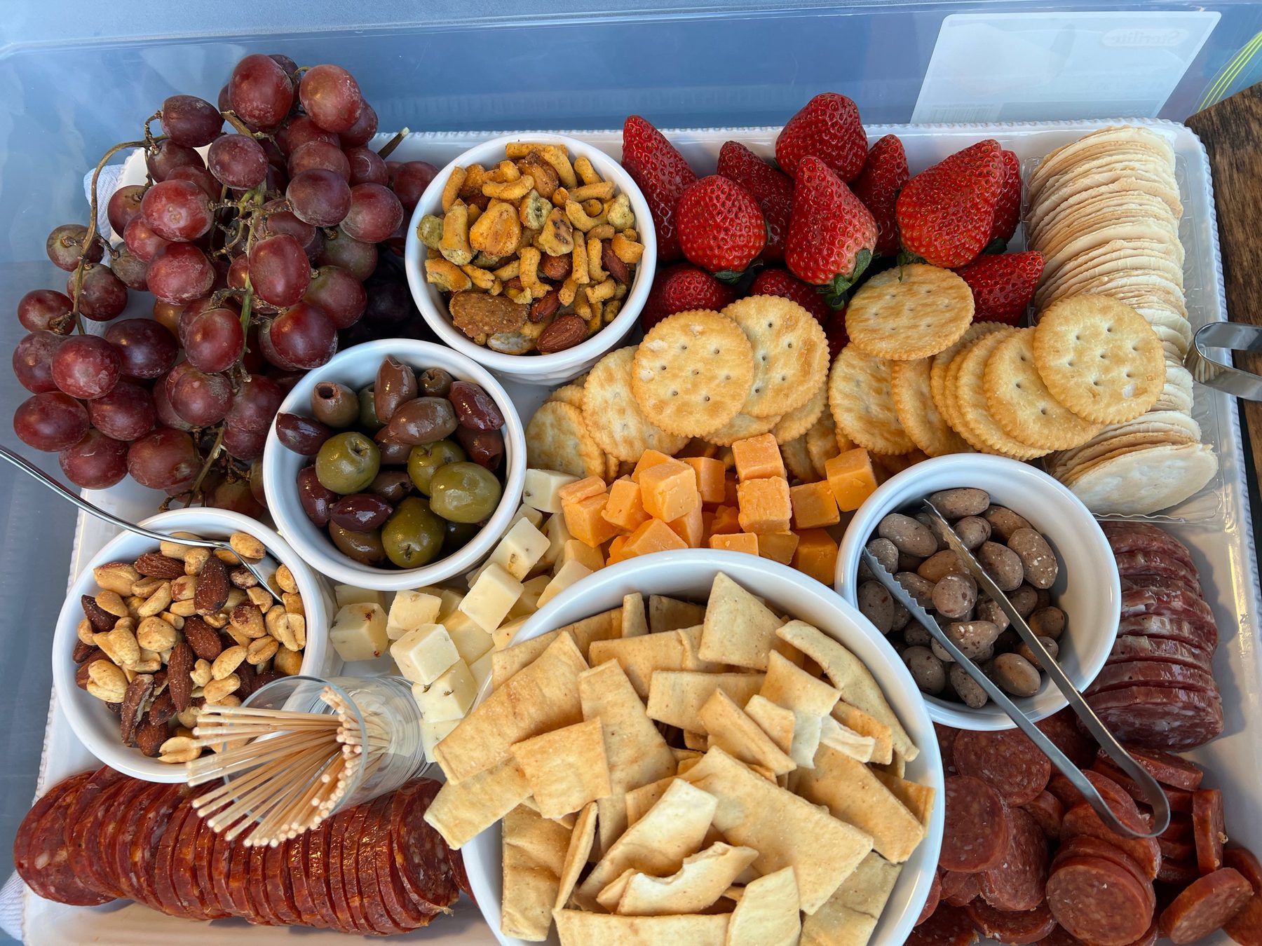 A curated grazing board at The Hive with cheeses, charcuterie, fresh grapes, strawberries and crackers