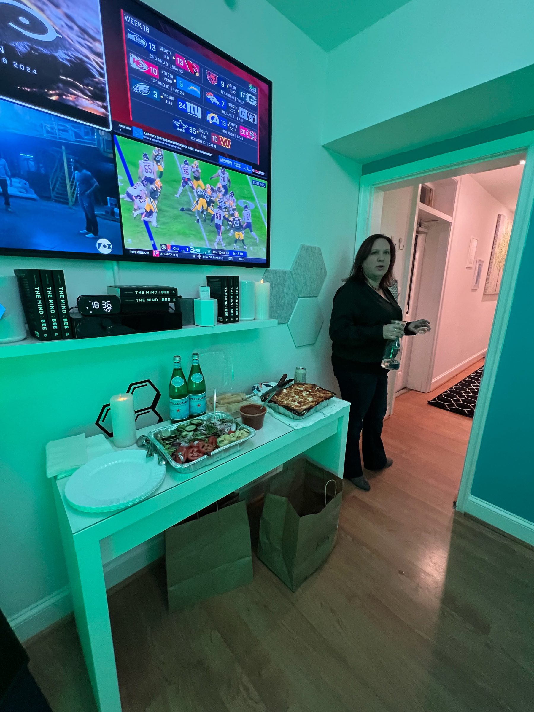 A watch party configuration at The Hive with multiple wall mounted screens showing live games above a snack station